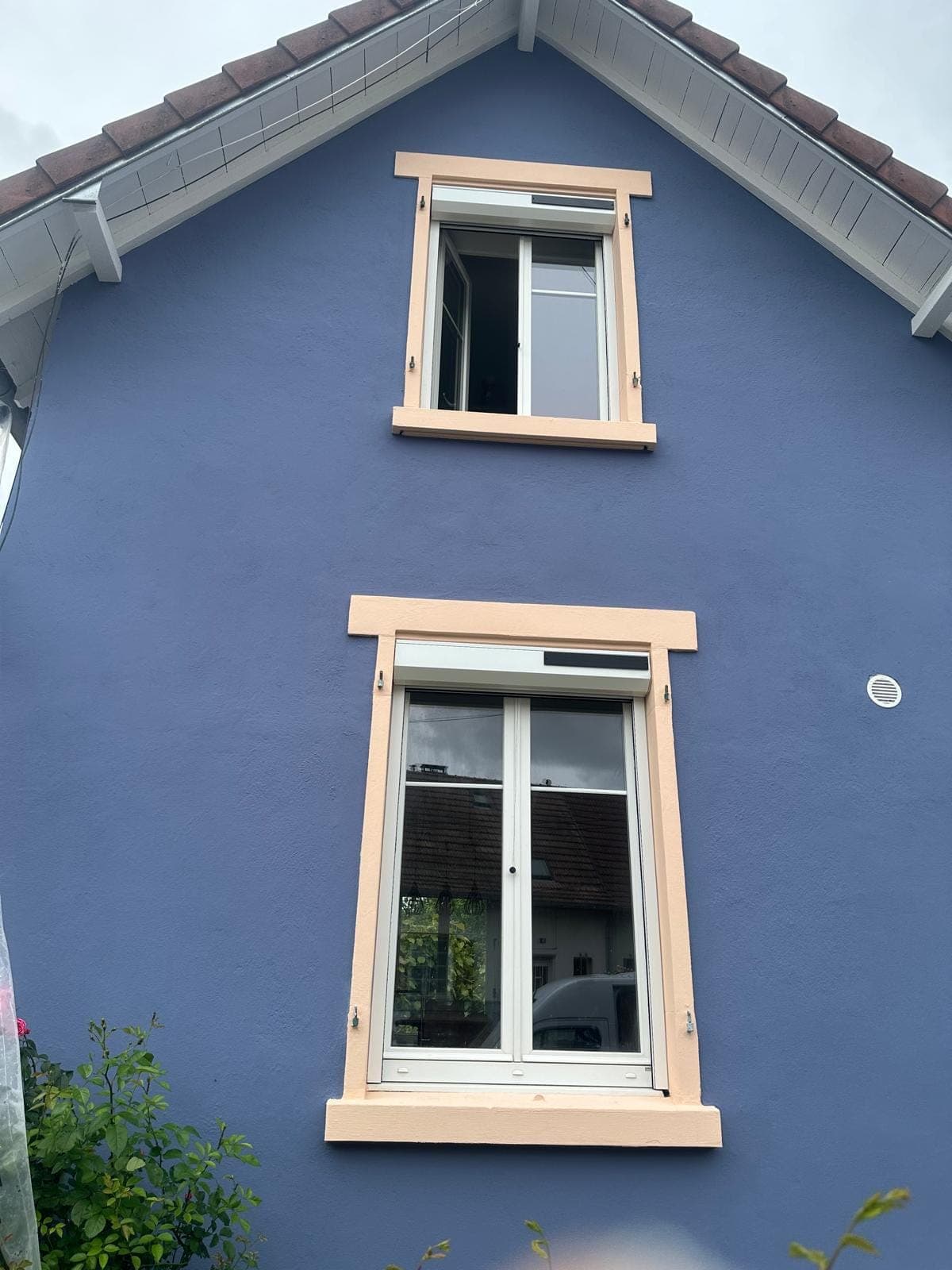 Façade bleue rénovée avec deux fenêtres PVC blanches et encadrements peints, par REM Fermetures