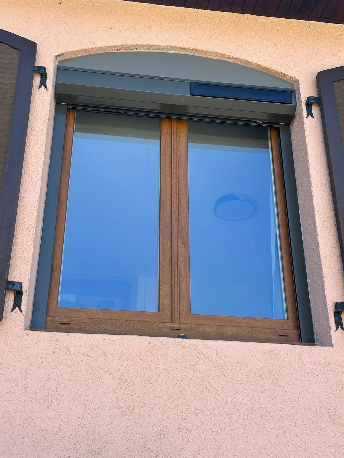 Fenêtre en bois à deux vantaux et imposte cintrée sur façade crépi, posée par REM Fermetures
