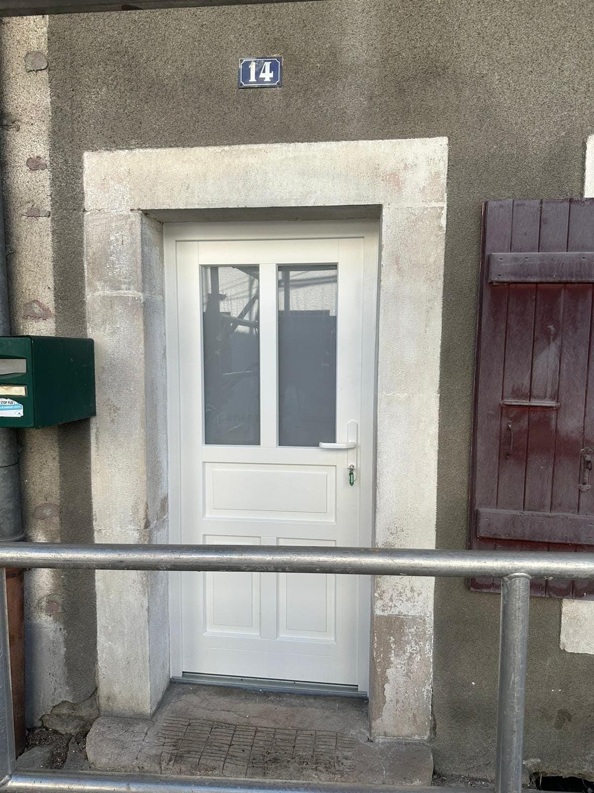 Porte d'entrée PVC blanche vitrée sur façade en pierre, posée par REM Fermetures